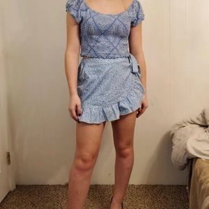 Blue floral print skirt with ruffles and bow on the side.